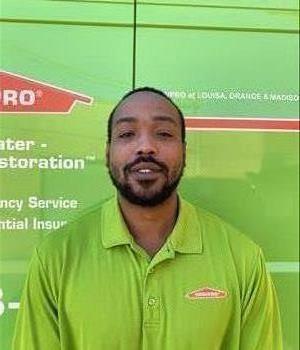 Male SERVPRO employee in green shirt with green water van in the background
