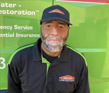 Male SERVPRO employee in a black shirt in front of the water van