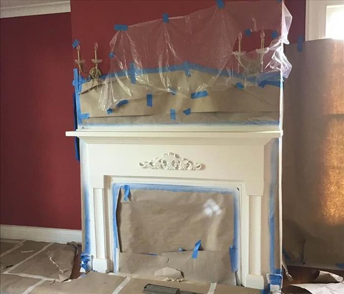 fireplace mid restoration with paper on walls 